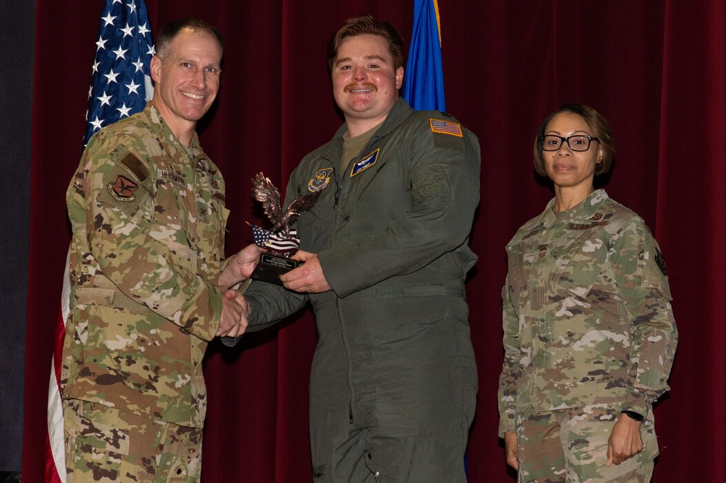 Col. Matt Husemann, left, 436th Airlift Wing commander and Chief Master Sgt. Tiffany Griego, right, 436th Mission Support Group senior enlisted leader, present Capt. Josh Wheeler, center, 3rd Airlift Squadron C-17 Globemaster III pilot, with a trophy during the 436th AW 4th Quarter Awards ceremony held at the Base Theater on Dover Air Force Base, Delaware, Jan. 26, 2023. Wheeler accepted the trophy on behalf of the 3rd Airlift Squadron operations team that was recognized as the wing’s Team of the Quarter. (U.S. Air Force photo by Roland Balik)