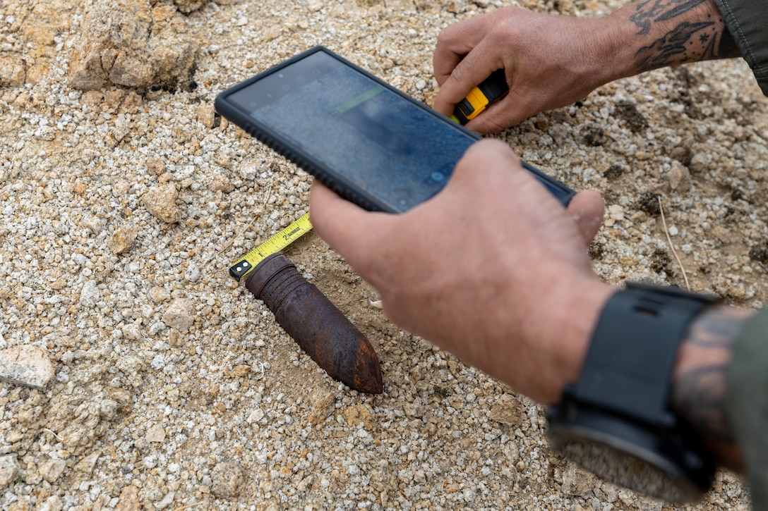 An explosive ordnance technician documents a projectile found in JTNP