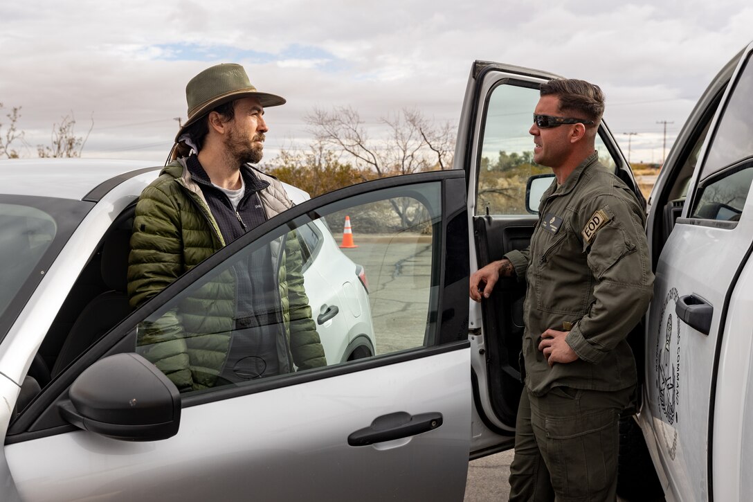 A JTNP Crew Leader speaks with a US Marine from explosive ordnance disposal