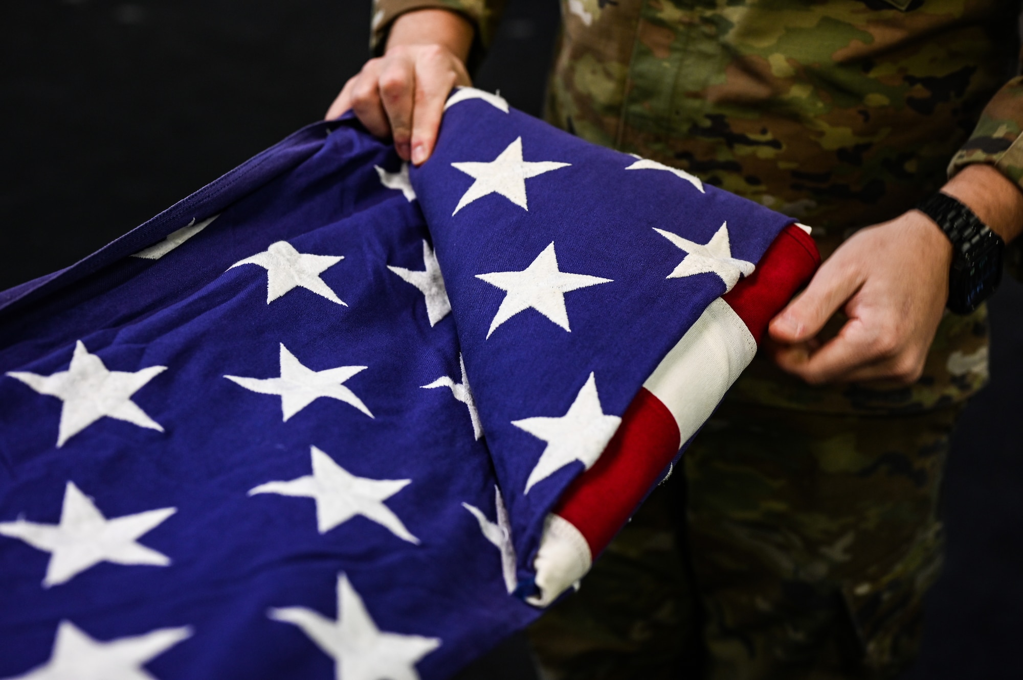 U.S. Air Force Airman 1st Class Devin Radford, 47th Operations Support Squadron aircrew flight equipment specialist, folds a flag during a Base Honor Guard practice at Laughlin Air Force Base, Texas, on Jan. 24, 2023. The American flag is folded in a particular way to symbolize important aspects of the flag and the nation it represents. (U.S. Air Force photo by Airman 1st Class Keira Rossman)