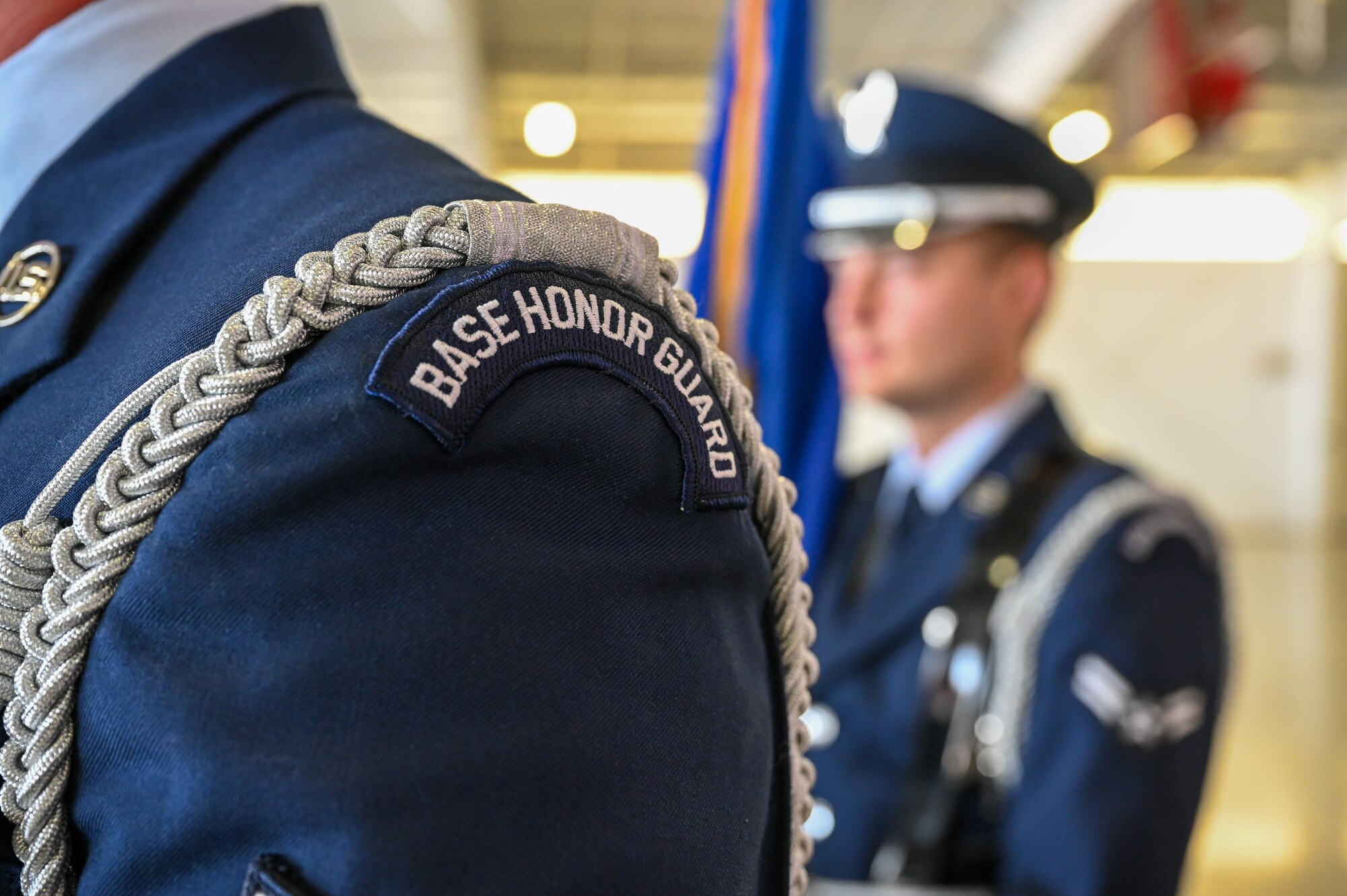 A photo displaying the shoulder of a U.S. Air Force ceremonial Guardsman wearing the “Base Honor Guard” identifier patch along with a silver rope at Laughlin Air Force Base, Texas, on July 7, 2022. The Air Force Honor Guard silver rope symbolizes the high level of proficiency and dedication required to be a member of the Air Force Honor Guard. (U.S. Air Force photo by Airman 1st Class Keira Rossman)