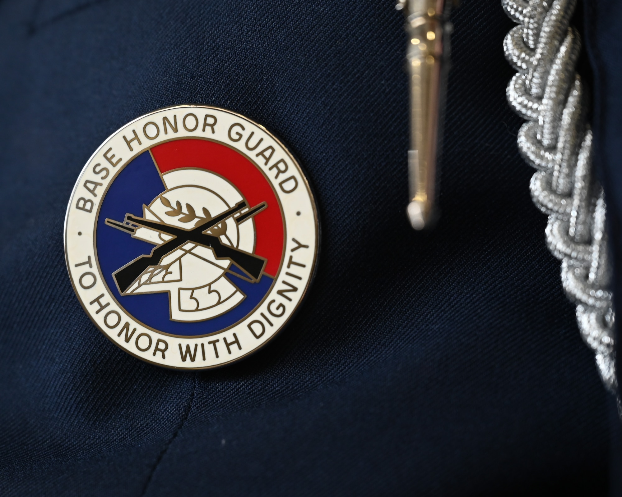 A U.S. Air Force ceremonial Guardsman’s badge at Laughlin Air Force Base, Texas, on July 7, 2022. The badge features a Roman helmet with a scarlet festoon and crossed M1 Garand rifles, all set against an ultramarine blue background. (U.S. Air Force photo by Airman 1st Class Keira Rossman)