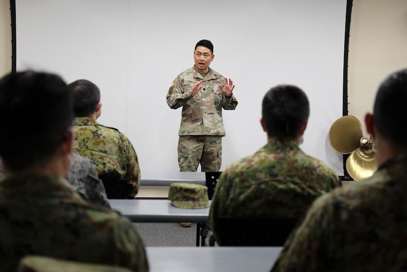 Chief Warrant Officer 2 Jason McElrath, left, vessel master of LCU Calaboza, briefs a group of Japan Ground Self-Defense Force leaders during a tour of the U.S. Army landing craft utility vessel at Yokohama North Dock, Japan, Jan. 25, 2023. (U.S. Army photo by Sean Kimmons)