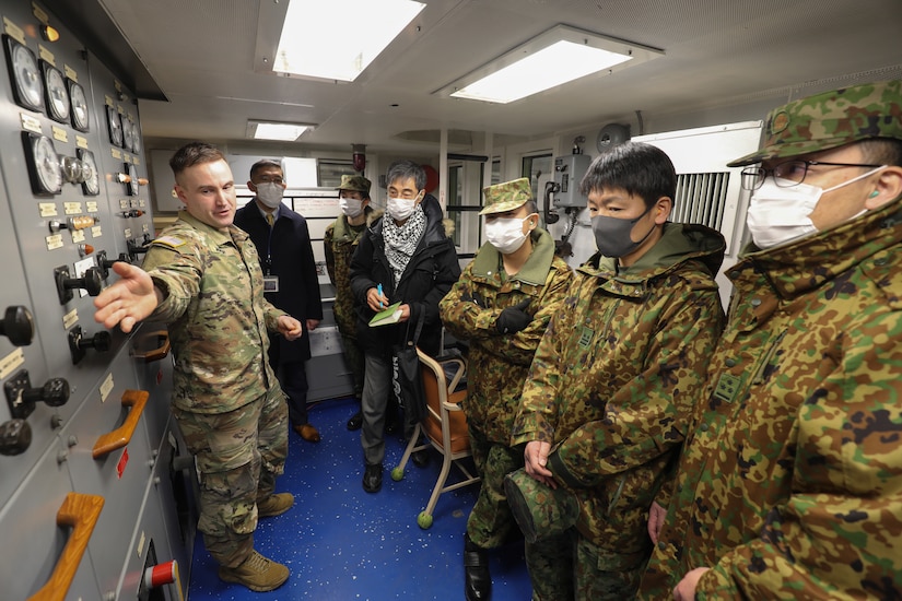Chief Warrant Officer 2 Jason McElrath, left, vessel master of LCU Calaboza, briefs a group of Japan Ground Self-Defense Force leaders during a tour of the U.S. Army landing craft utility vessel at Yokohama North Dock, Japan, Jan. 25, 2023. (U.S. Army photo by Sean Kimmons)