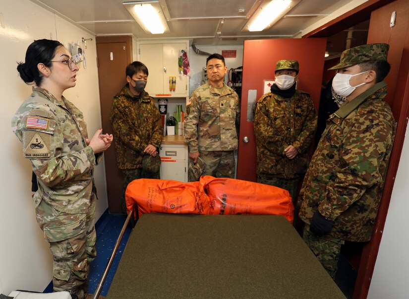 Chief Warrant Officer 2 Jason McElrath, left, vessel master of LCU Calaboza, briefs a group of Japan Ground Self-Defense Force leaders during a tour of the U.S. Army landing craft utility vessel at Yokohama North Dock, Japan, Jan. 25, 2023. (U.S. Army photo by Sean Kimmons)