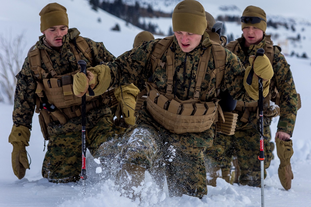 Marines hike in the snow.