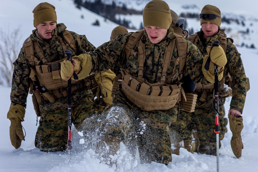 Marines hike in the snow.