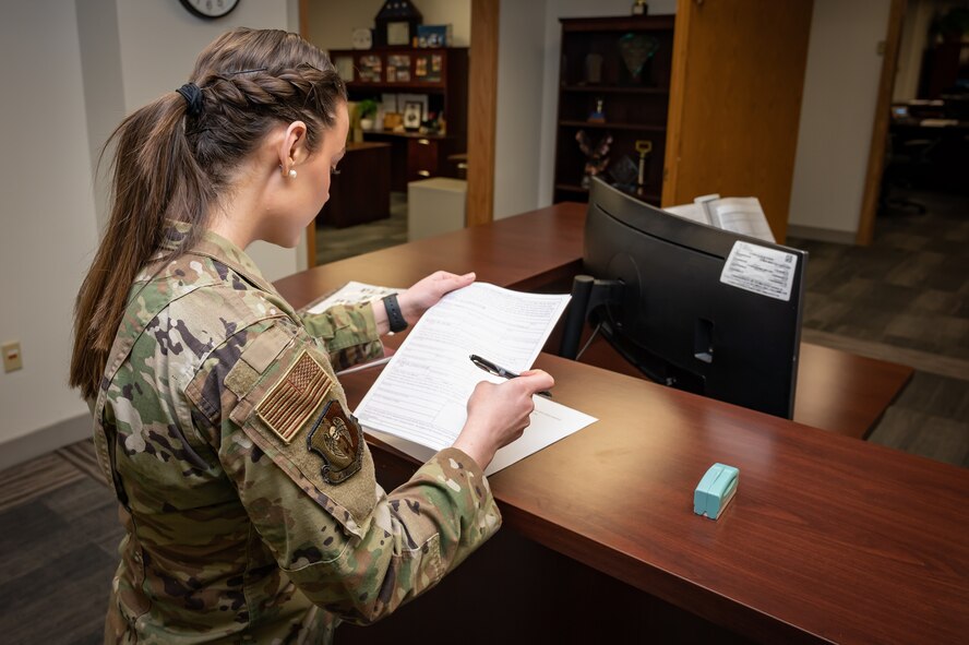 U.S. Air Force Senior Airman Jessica Ramsay, 5th Bomb Wing Legal Office civil law paralegal, notarizes a document for an Airman at Minot Air Force Base, North Dakota, Jan. 24, 2023. She was one of two Airmen selected by Gen. Anthony J. Cotton, the previous commander of Air Force Global Strike Command, for a spot in the Senior Leader Enlisted Commissioning Program. (U.S. Air Force photo by Airman 1st Class Alexander Nottingham)