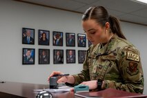 U.S. Air Force Senior Airman Jessica Ramsay, 5th Bomb Wing Legal Office civil law paralegal, notarizes a document for an Airman at Minot Air Force Base, North Dakota, Jan. 24, 2023. She was one of two Airmen selected by Gen. Anthony J. Cotton, the previous commander of Air Force Global Strike Command, for a spot in the Senior Leader Enlisted Commissioning Program. (U.S. Air Force photo by Airman 1st Class Alexander Nottingham)