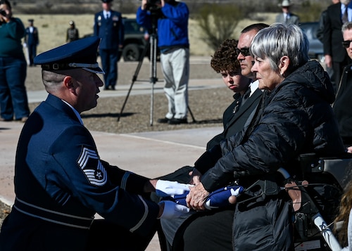 A member of the U.S. Air Force Honor Guard presents the American flag to Paula Desmarasis, the daughter of retired Chief Master Sgt. Paul Kerchum, during his interment ceremony at Southern Arizona Memorial Veterans Cemetery, Sierra Vista, Ariz., Jan. 25, 2023. Kerchum died Dec. 17, 2022, and was laid to rest with full military honors on what would have been his 103rd birthday. He was a World War II POW and the last survivor of the 65-mile Bataan Death March in the Philippine Islands. (U.S. Air Force photo by Airman 1st Class Paige Weldon)