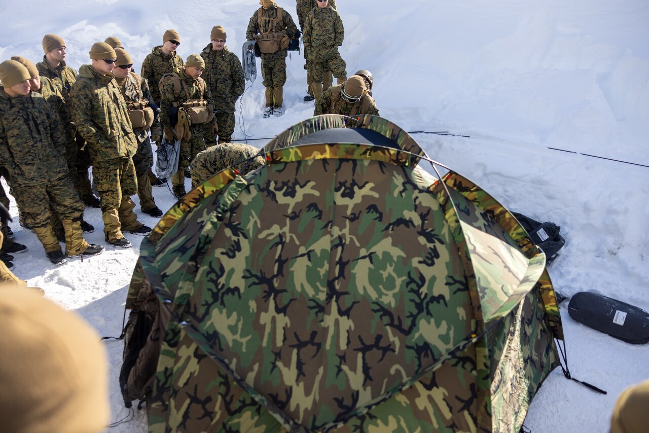Marines sent up a tent in the snow.
