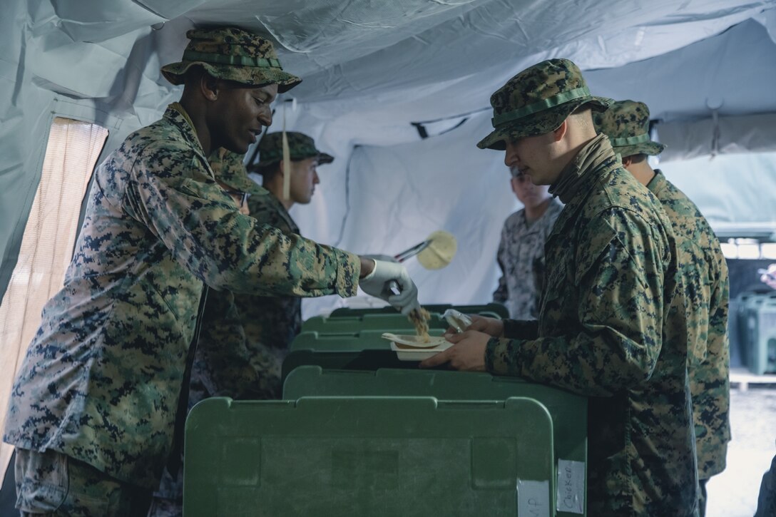 U.S. Marines with Combat Service Support Company, I Marine Expeditionary Force Support Battalion, I MEF Information Group, serve food to Marines after the William Pendleton Thompson Hill Award inspection on Marine Corps Base Camp Pendleton, Dec. 7, 2021. The W.P.T. Hill Award recognizes the best mess halls in the Marine Corps, all competitors are judged in operations, sanitation, taste, and quality of food. (U.S. Marine Corps photo by Lance Cpl. Gadiel Zaragoza)