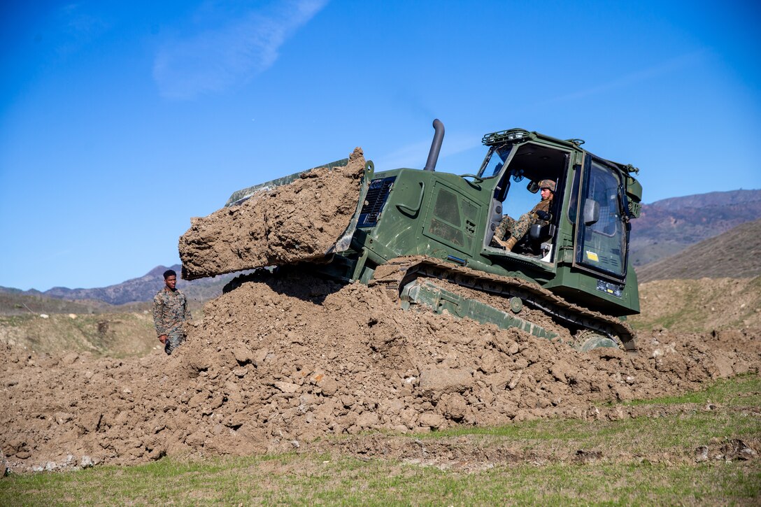 U.S. Marine Corps Lance Cpl. Laurian Cardenas, an engineer equipment operator with I Marine Expeditionary Force Support Battalion, I MEF Information Group, operates a D6 bulldozer to build burms during a Combat Service Support Company field exercise at Marine Corps Base Camp Pendleton, California, Dec. 14, 2022. CSSC conducted the field exercise to meet operational and training objectives to enhance deployment capabilities and unit readiness. (U.S. Marine Corps photo by Sgt. Alize Sotelo)