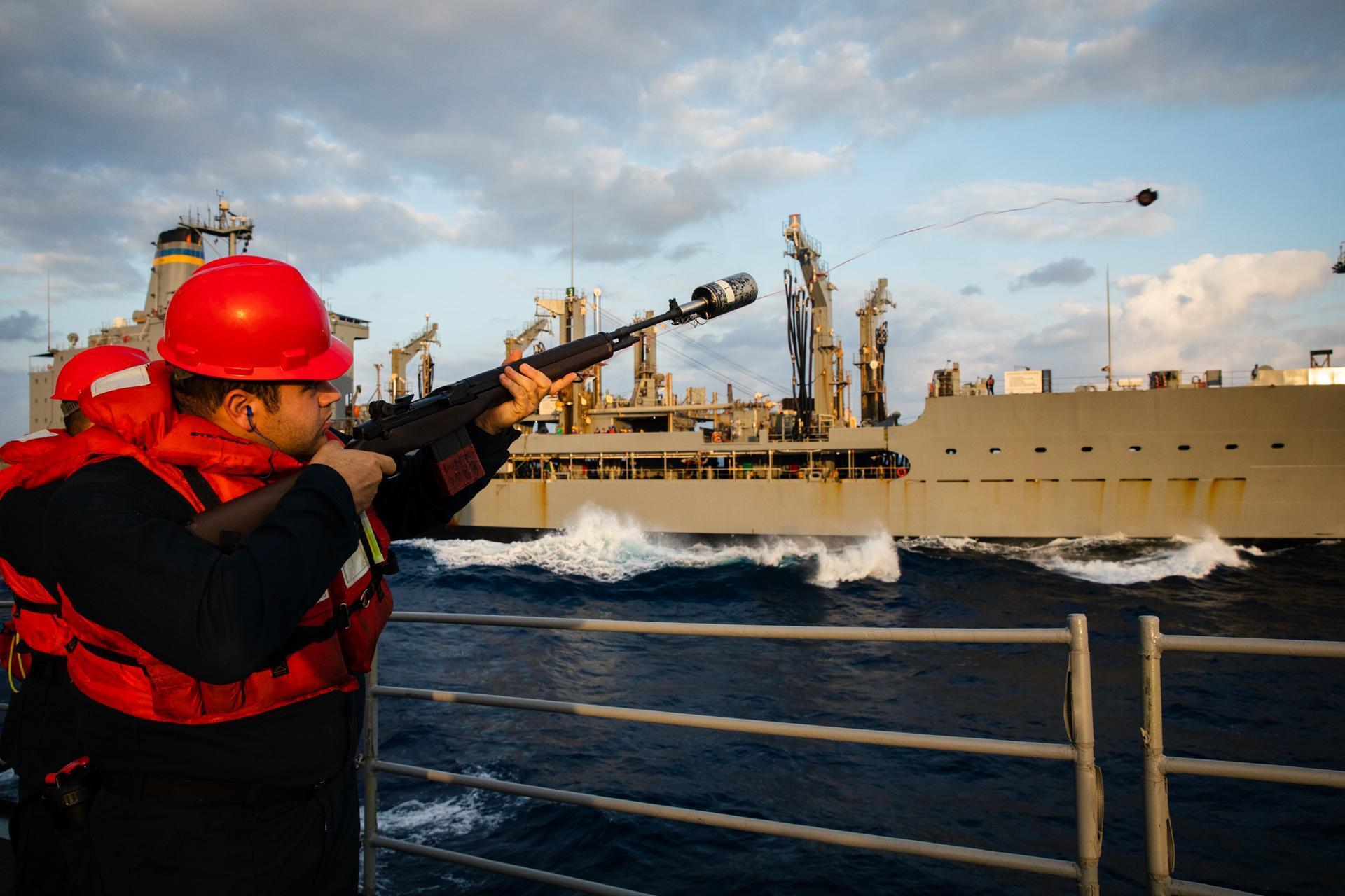 U.S. Navy Fire Controlman (Aegis) 2nd Class Spencer Allen, from Griffin, Ga., fires a shot line from the Ticonderoga-class guided-missile cruiser USS Bunker Hill (CG 52) during a replenishment at sea with the Henry J. Kaiser-class fleet replenishment oiler USNS Guadalupe (T-AO 200), Jan. 22, 2023.