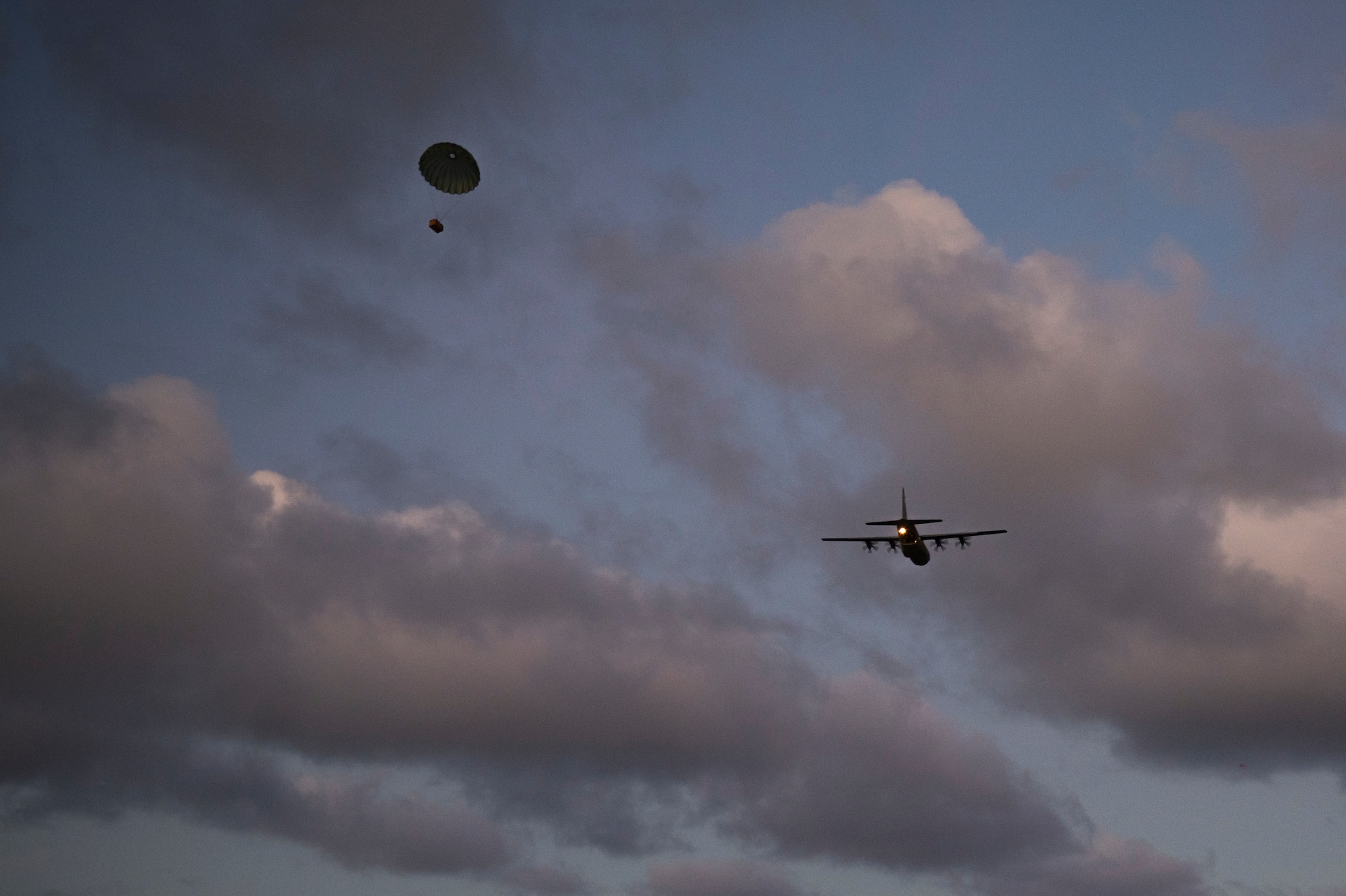 A C-130J Super Hercules makes an airdrop as a part of a training exercise over Pacific Regional Training Center, Andersen Air Force Base, Guam, Jan. 19, 2023. The 36th Contingency Response Squadron was conducting a training exercise to set up a drop zone while the C-130J Super Hercules crew aimed to put the drops on target. (U.S. Air Force photo by Airman 1st Class Spencer Perkins)