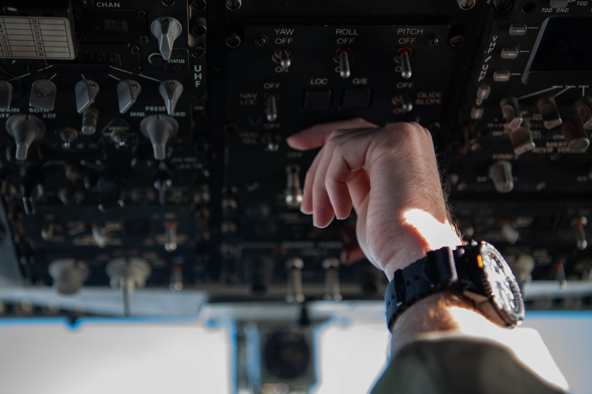 An Airman flips an aircraft's switches.