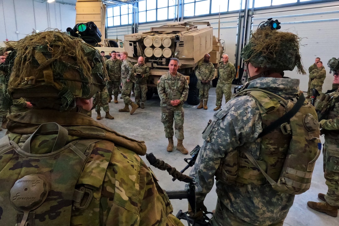 A senior officer stands and speaks in front of soldiers during a  ceremony.