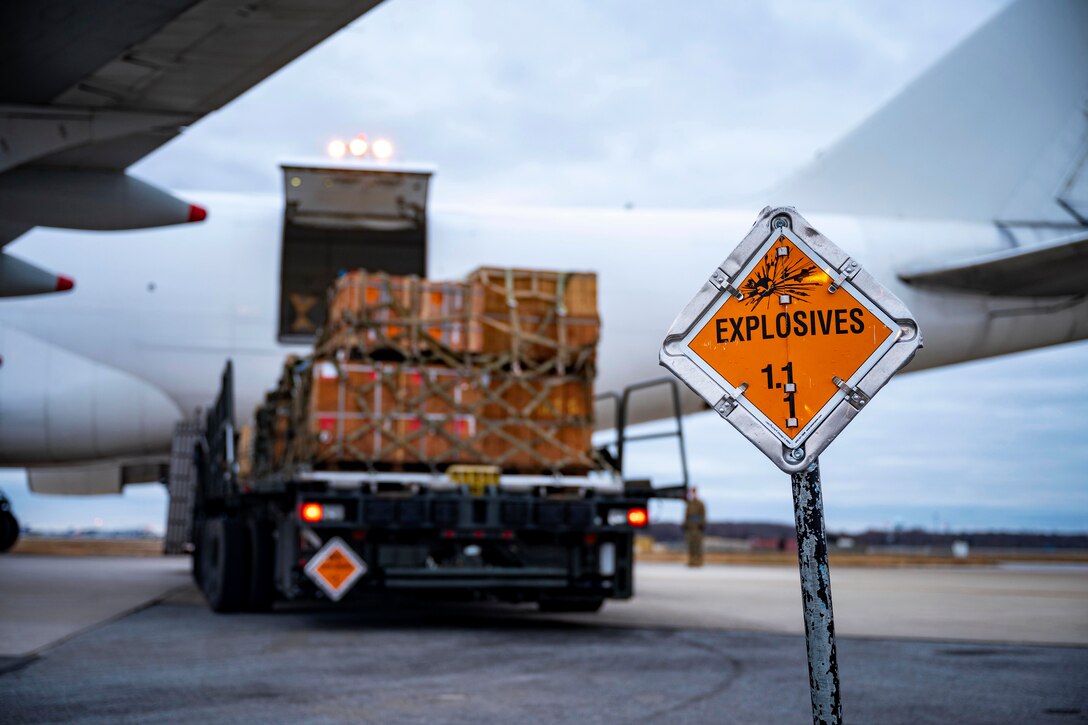 An explosive sign behind a vehicle marks the safe area around an aircraft and the vehicle offloading explosives.