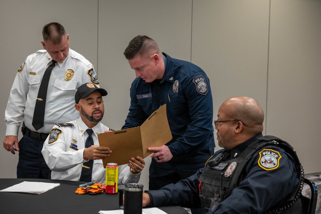 Naval District Washington police officers review a resume at the law enforcement and public safety job fair held at the Harborside Hotel in Oxon Hill, MD.