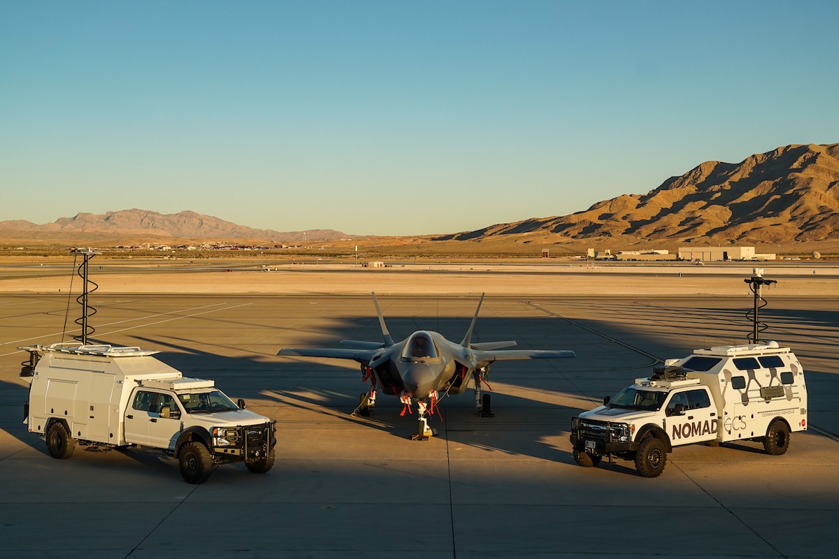 An F-35A Lighting II and Multi-Utilization Secure Tactical And Network Ground Station (MUSTANGS) are pictured on the flight line at Nellis Air Force Base, Nevada, Nov. 16, 2022. Part of the Crowd-Sourced Flight Data (CSFD) program, MUSTANGS is a mobile vehicle that can download, process, and offload important data from Quick Reaction Instrumentation Package (QRIP) equipped aircraft without the need for fixed operational test infrastructure. (U.S. Air Force Photo by Airman 1st Class Trevor Bell)