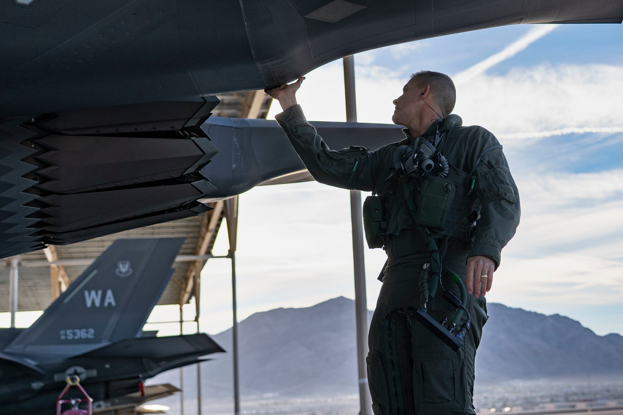 Brig. Gen. Michael Rawls, Air Force Operational Test and Evaluation Center commander, performs a pre-flight check on an F-35A Lightning II at Nellis Air Force Base, Nevada, Jan. 12, 2023. Gen. Rawls is committed to the continued modernization of the Air Force to ensure the United States remains at the forefront of air power. (U.S. Air Force photo by Airman First Class Trevor Bell)