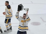 MMN1 Jake Feldman hoists a trophy over his head at the Navy vs. Army game in 2022.