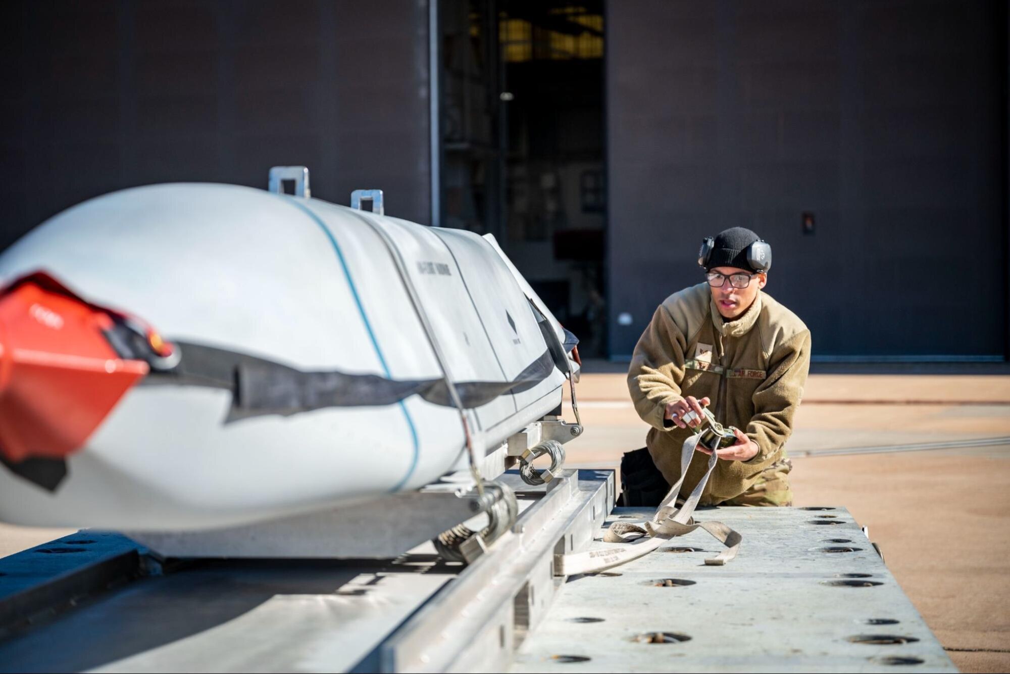 A load crew member assigned to the 28th Aircraft Maintenance Unit, prepares to transport an inert Joint Air-to-Surface Standoff Missile to a B-1B Lancer during the Load Crew of the Year competition at Dyess Air Force Base, Texas, Jan. 27, 2023. Munitions Systems Airmen competed in a bomb loading challenge to see who could load munitions the fastest while adhering to safety guidance and procedures. (U.S. Air Force photo by Senior Airman Leon Redfern)