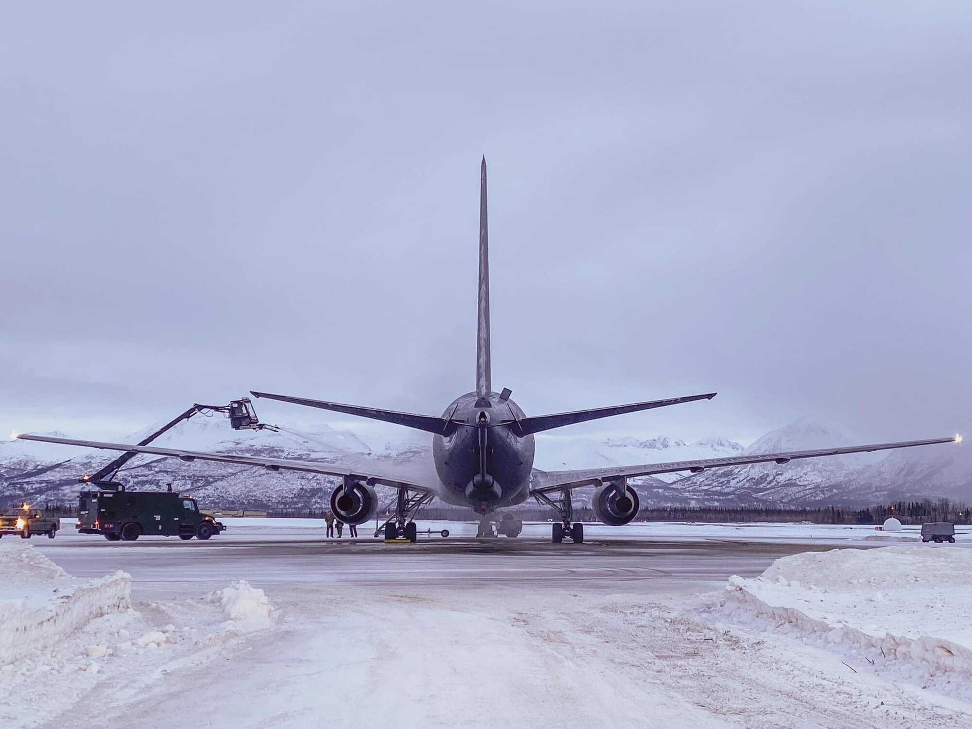 Airmen de-ice a military aircraft.