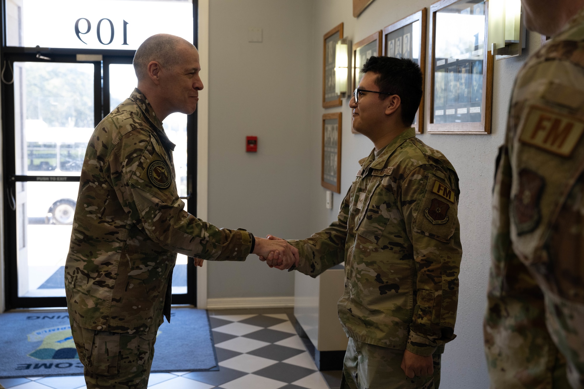 U.S. Air Force Gen. Thomas Bussiere, Air Force Global Strike Command commander, presents a coin to Airman 1st Class Jacob Romero, financial planner at the 2nd Comptroller Squadron, during a base tour, Barksdale Air Force Base, La., Jan. 26, 2023.