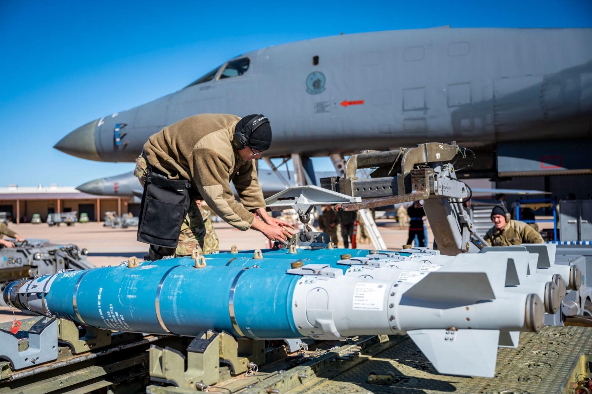 Weapons load crew members assigned to the 28th Aircraft Maintenance Unit, attach an inert bomb to a jammer during the Load Crew of the Year competition at Dyess Air Force Base, Texas, Jan. 27, 2023. The 9th and 28th AMU both competed against each other during the load competition. (U.S. Air Force photo by Senior Airman Leon Redfern)