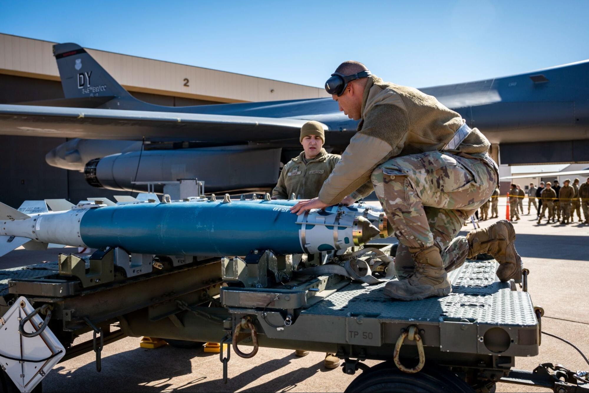 Weapons load crew members assigned to the 9th Aircraft Maintenance Unit, prepare to transport an inert bomb to a B-1B Lancer during the Load Crew of the Year competition at Dyess Air Force Base, Texas, Jan. 27, 2023. Munitions Systems Airmen are enlisted Airmen that are tasked with protecting, handling, storing, transporting, arming/disarming and assembly of non-nuclear munitions. (U.S. Air Force photo by Senior Airman Leon Redfern)