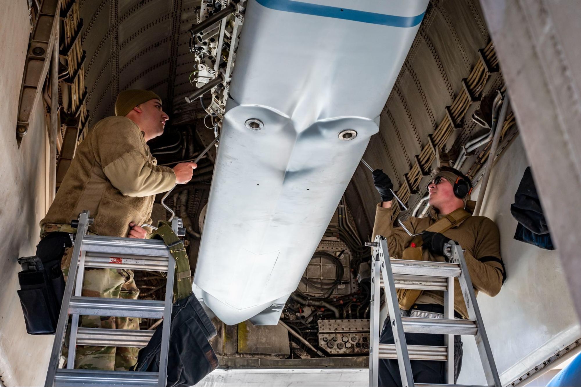 Weapons load crew members assigned to the 9th Aircraft Maintenance Unit, lock in an inert Joint Air-to-Surface Standoff Missile to a B-1B Lancer during the Load Crew of the Year competition at Dyess Air Force Base, Texas, Jan. 27, 2023. The 9th and 28th AMU both competed against each other during the load competition. (U.S. Air Force photo by Senior Airman Leon Redfern)