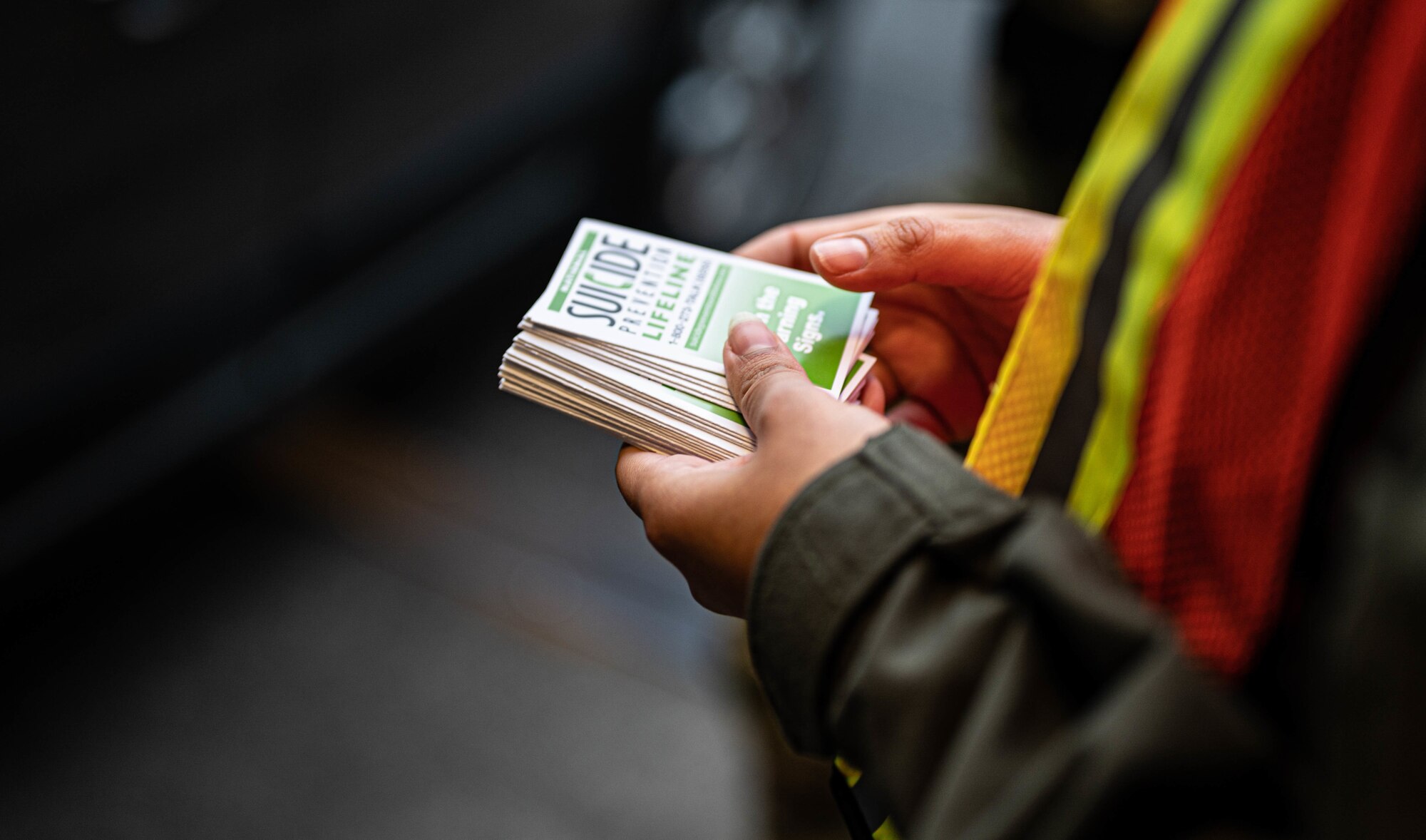 U.S. Air Force Tech. Sgt. Karla De Los Santos, deputy raven program manager with the 627th Security Forces Squadron, hands out suicide prevention information cards at the McChord main gate at Joint Base Lewis-McChord, Washington, Sept. 1, 2022. Suicide Prevention Month is observed every September.