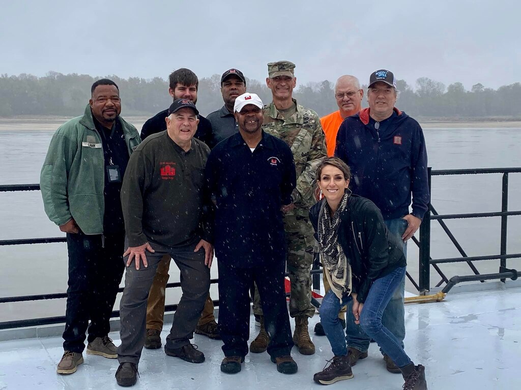 A photo of Jessica Haas, December 2022 Employee of the Month, with the Dredge Hurley Veterans.

Haas is the principal writer in the Public Affairs Office. She writes about everything from the Memphis District reaching important project milestones to the Dredge Hurley crew out working during the cold Christmas Holidays. She is also our extraordinary website and social media manager who has the Memphis District positioned number one in MVD for the most followers. 

You would expect all that’s been mentioned about what Jessica does is hard work and it is. However, if you ask her about it, you’ll get a different perspective. 

"I'm the lucky one here," Haas explains. "When you love what you do, it isn’t work anymore. It’s an honor to be around and interact with such a talented team of professionals every day. If this is a dream, I never want to wake up."