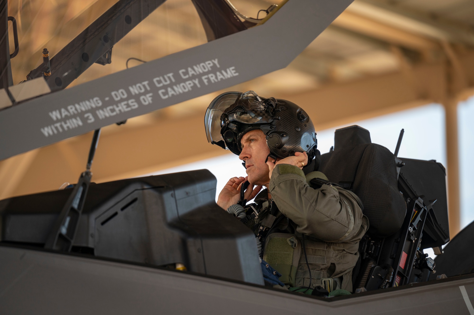Brig. Gen. Michael Rawls, Air Force Operational Test and Evaluation Center (AFOTEC) commander, secures his helmet in an F-35A Lightning II at Nellis Air Force Base, Nevada, Jan. 12, 2023. As the commander of AFOTEC, Gen. Rawls is responsible for the independent testing and evaluation of new and existing systems for the Air Force. (U.S. Air Force Photo by Airman First Class Trevor Bell)