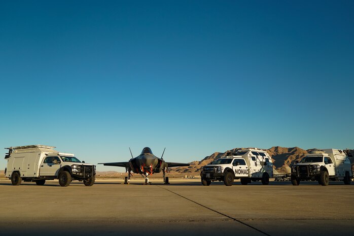 An F-35A Lighting II and Multi-Utilization Secure Tactical And Network Ground Stations (MUSTANGS) are pictured on the flight line at Nellis Air Force Base, Nevada, Nov. 16, 2022. Part of the Crowd-Sourced Flight Data (CSFD) program, MUSTANGS is a mobile vehicle that can download, process, and offload important data from Quick Reaction Instrumentation Package (QRIP) equipped aircraft without the need for fixed operational test infrastructure. (U.S. Air Force Photo by Airman 1st Class Trevor Bell)