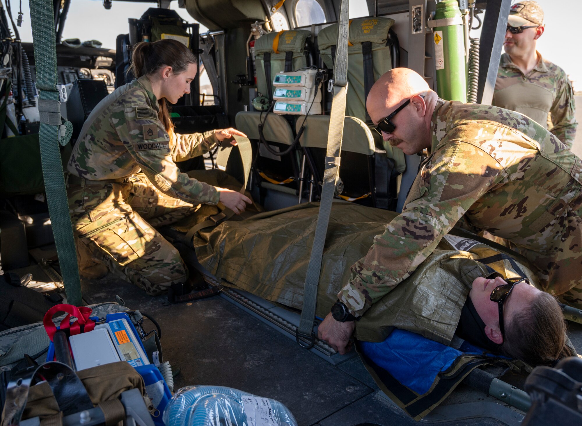 U.S. Army Soldiers practice strapping down a patient in the cabin of a UH-60 Blackhawk helicopter at Ali Al Salem Air Base, Kuwait, Jan. 20, 2023.