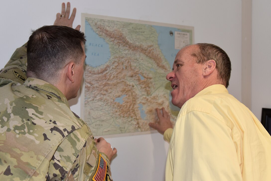 U.S. Army Corps of Engineers, Europe District Contracting Officer Master Sgt. Aaron Kopecky and Europe District Chief of Contracting Chris Tew discuss projects in the Caucasus region while looking at a map in Europe District offices in Wiesbaden, Germany January 10, 2023, Europe District manages construction of a variety of projects in multiple countries in the Caucasus region. Kopecky is one of four Soldiers serving in the Contracting Division and while they support a wide range of projects, they often support some of the District’s more remote construction efforts. (U.S. Army photo by Chris Gardner)