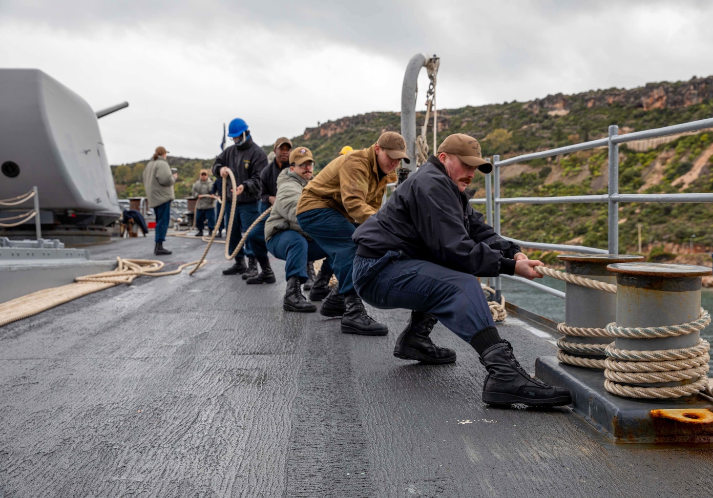 (Jan. 30, 2023) Sailors assigned to the Ticonderoga-class guided-missile cruiser USS Leyte Gulf (CG 55) heave line from the pier as the ship arrives in Souda Bay, Greece, for a scheduled port visit, Jan. 30, 2023. The George H.W. Bush Carrier Strike Group is on a scheduled deployment in the U.S. Naval Forces Europe area of operations, employed by U.S. Sixth Fleet to defend U.S., allied, and partner interests.