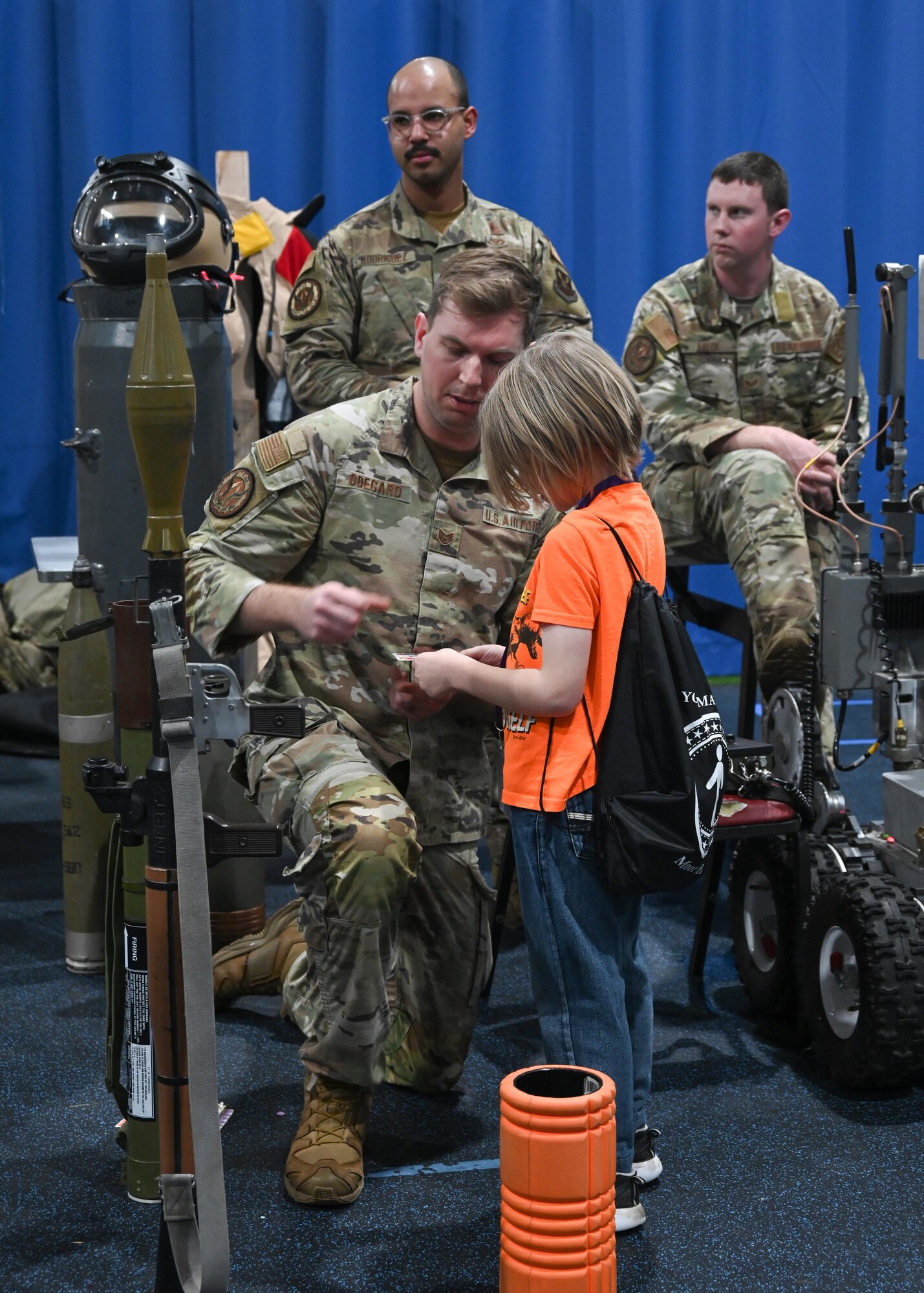 U.S. Air Force Staff Sgt. Spencer Odegard from the 5th Explosive Ordnance Disposal Squadron shows children how to operate a bomb defusing robot as part of Operation Hero in the Community Complex Center at Minot Air Force Base, North Dakota, Jan. 20, 2023. Volunteer Airmen from 20 different agencies within the 5th Bomb Wing and 91st Missile Wing showcased their duties, conducted demonstrations, and provided interactive experiences to over 150 families. (U.S. Air Force photo by Senior Airman Caleb S. Kimmell)