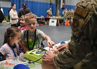 U.S. Air Force Airman First Class Easton Jones, 5th Healthcare Operations Squadron 
ambulance service medical technician, teaches families and their children emergency breathing techniques as part of Operation Hero at the Community Complex Center at Minot Air Force Base, North Dakota, Jan. 20, 2023. Volunteer Airmen from 20 different agencies within the 5th Bomb Wing and 91st Missile Wing showcased their duties, conducted demonstrations, and provided interactive experiences to over 150 families. (U.S. Air Force photo by Senior Airman Caleb S. Kimmell)