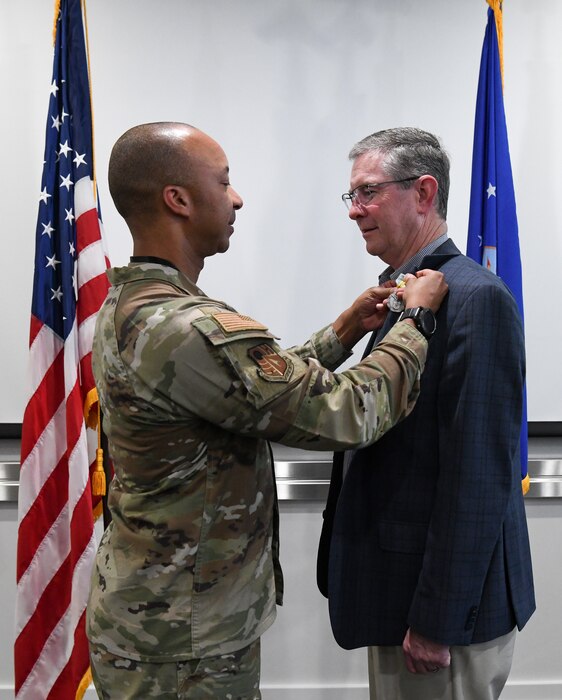 Air Force colonel pinning medal on civilian