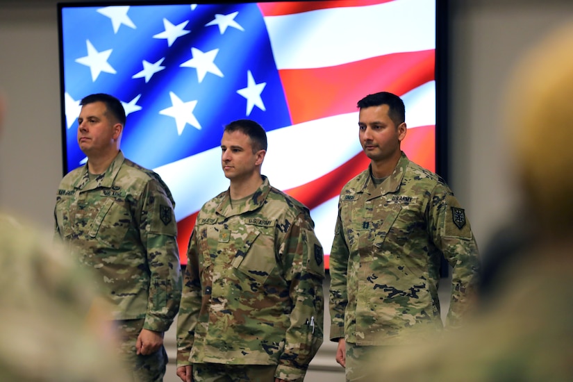 Three Soldiers stand at a formation facing the audience.