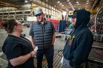 Jeremy Stephens, trade superintendent, Shop 11 and Shop 17, Sheetmetal and Shipfitters, chats with co-workers inside Building 460, March 21, 2022, at Puget Sound Naval Shipyard & Intermediate Maintenance Facility in Bremerton, Washington. (U.S. Navy photo by Scott Hansen)