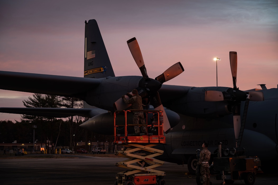 Members of the 103rd Maintenance Group inspect the propeller of a C-130H Hercules aircraft, December 13, 2021, East Granby, Connecticut. The maintainers began preparing the aircraft for flight at sunrise. (U.S. Air National Guard photo by Master Sgt. Tamara R. Dabney)