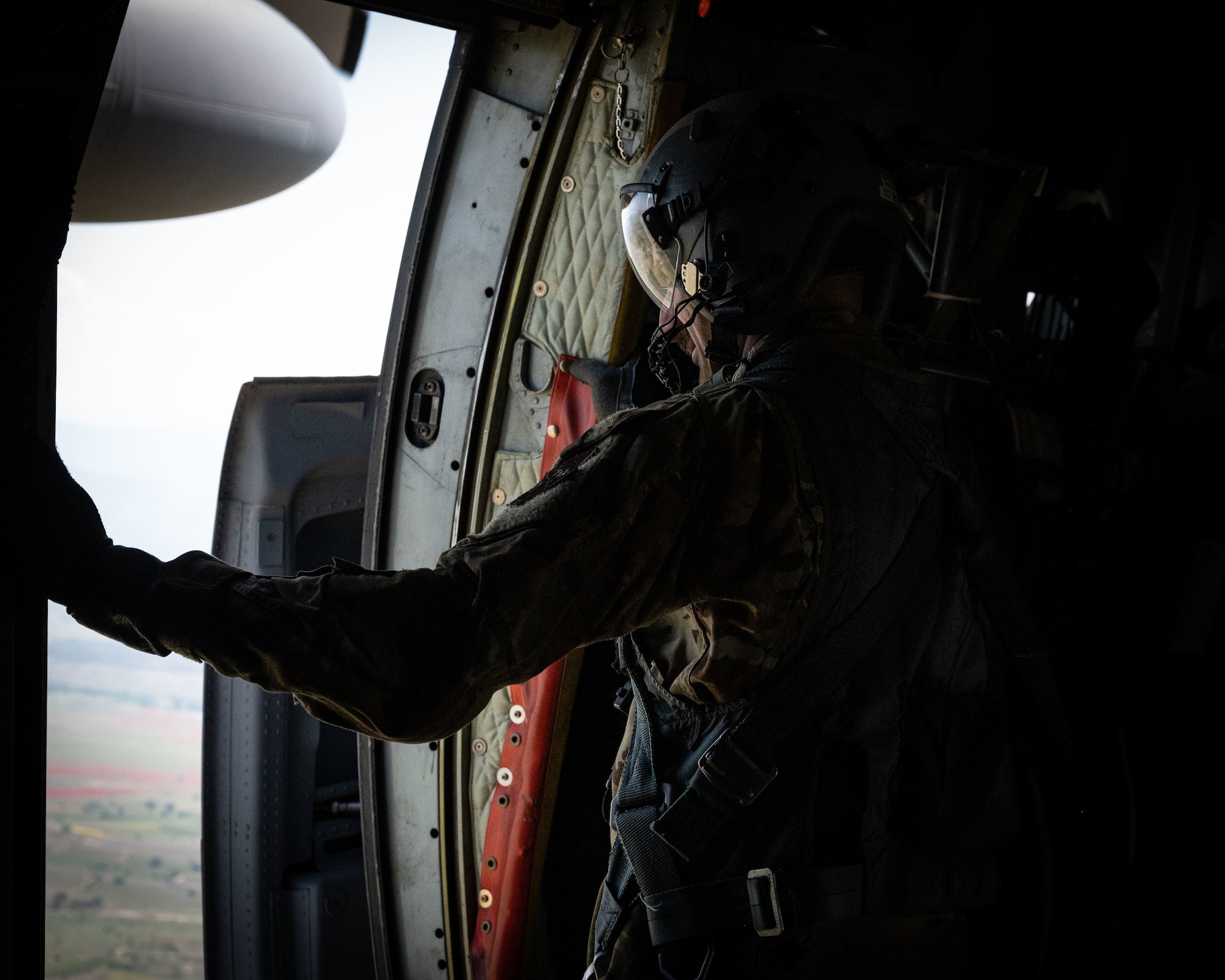 Air Force Tech. Sgt. Radek Kret, an aircraft loadmaster assigned to the 103rd Operations Group, 103rd Airlift Wing, Connecticut Air National Guard examines the airdrop zone in
preparation for a jump during an airdrop mission, as part of Exercise Swift Response 22, May 11, 2022, in Pisa, Italy. The exercise focused on building airborne interoperability with allies and partners, and the integration of joint service partners in a contested environment. Military exercises with Allied and partner nations in the European and African theaters are an integral part of demonstrating Alliance readiness, interoperability and capability. (U. S. Air National Guard photo by Master Sgt. Tamara R. Dabney)