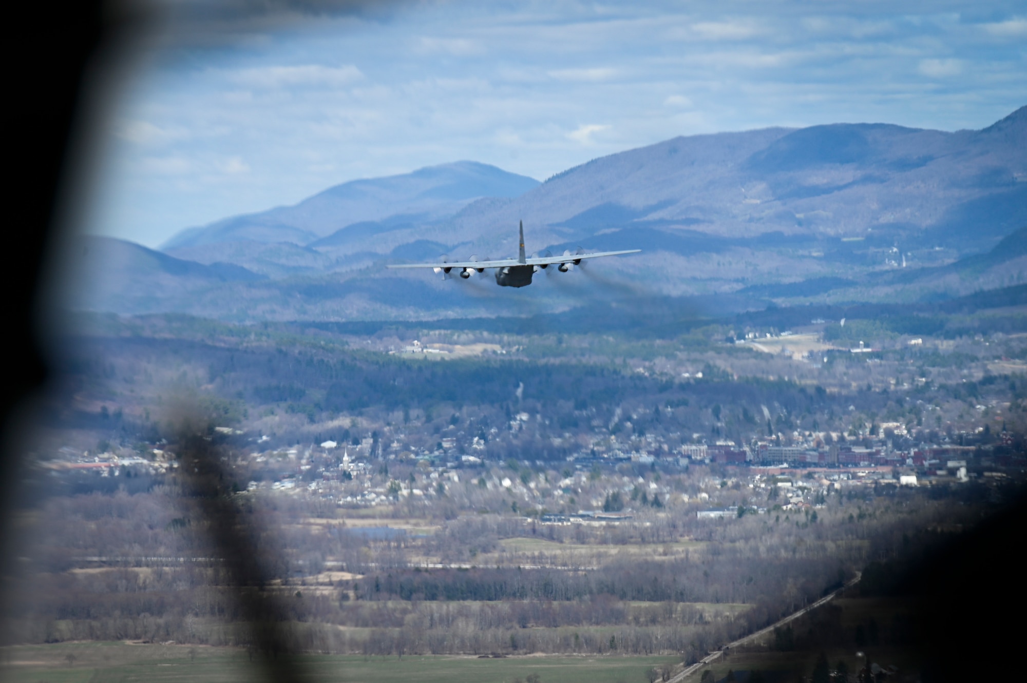 A C-130H Hercules from the 103rd Airlift Wing flies as part of a two-ship formation during a training mission over New England, April 7, 2021. during a training mission over New England, April 7, 2021. The 103rd Airlift Wing routinely flies local training missions to sharpen key tactical airlift capabilities. (U.S. Air National Guard photo by Tech. Sgt. Steven Tucker)