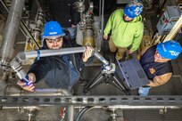 Shop 56 pipefitters (from left) Mitchell Clearly, Brandon Bliss and Chris Foust demonstrate the use of the new, portable FARO Arm at the NBK Pure Water Plant December 12, 2022 at Naval Base Kitsap-Bremerton, Washington. (U.S. Navy photo by Scott Hansen)