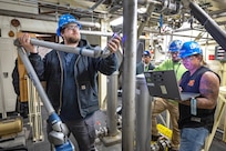 Shop 56 pipefitters (from left) Mitchell Clearly, Brandon Bliss and Chris Foust demonstrate the use of the new, portable FARO Arm at the NBK Pure Water Plant December 12, 2022 at Naval Base Kitsap-Bremerton, Washington. (U.S. Navy photo by Scott Hansen)