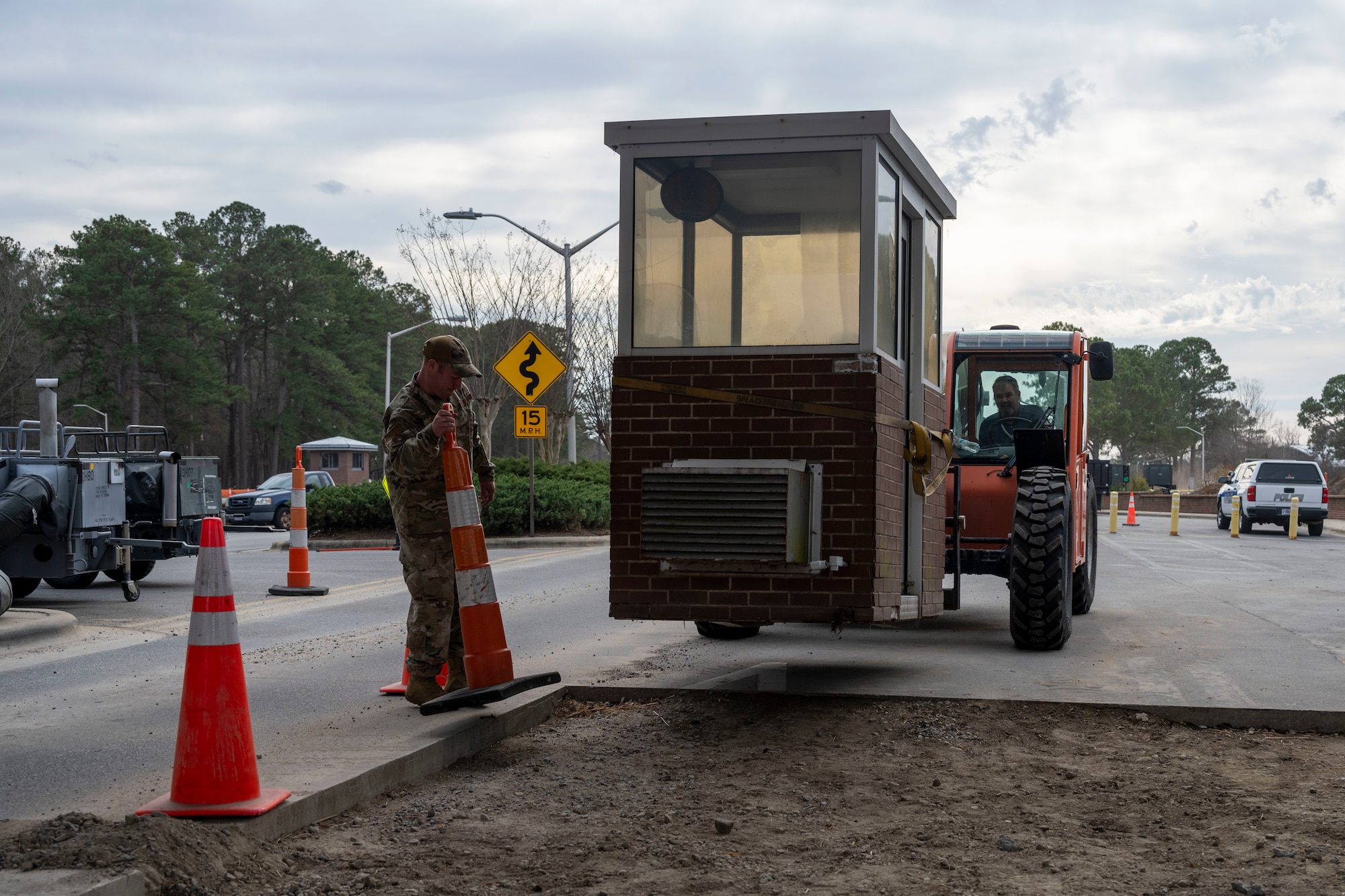 Tech. Sgt. Brian Ashworth and Paul Walker, both 4th CES pavements and equipment technicians, position a pre-engineered building during a sight survey at Seymour Johnson Air Force Base, North Carolina, Jan. 3, 2023. The PEB was positioned as a model building in order to properly measure clearance for passing vehicles after the gate’s update. (U.S. Air Force photo by Senior Airman Kevin Holloway)